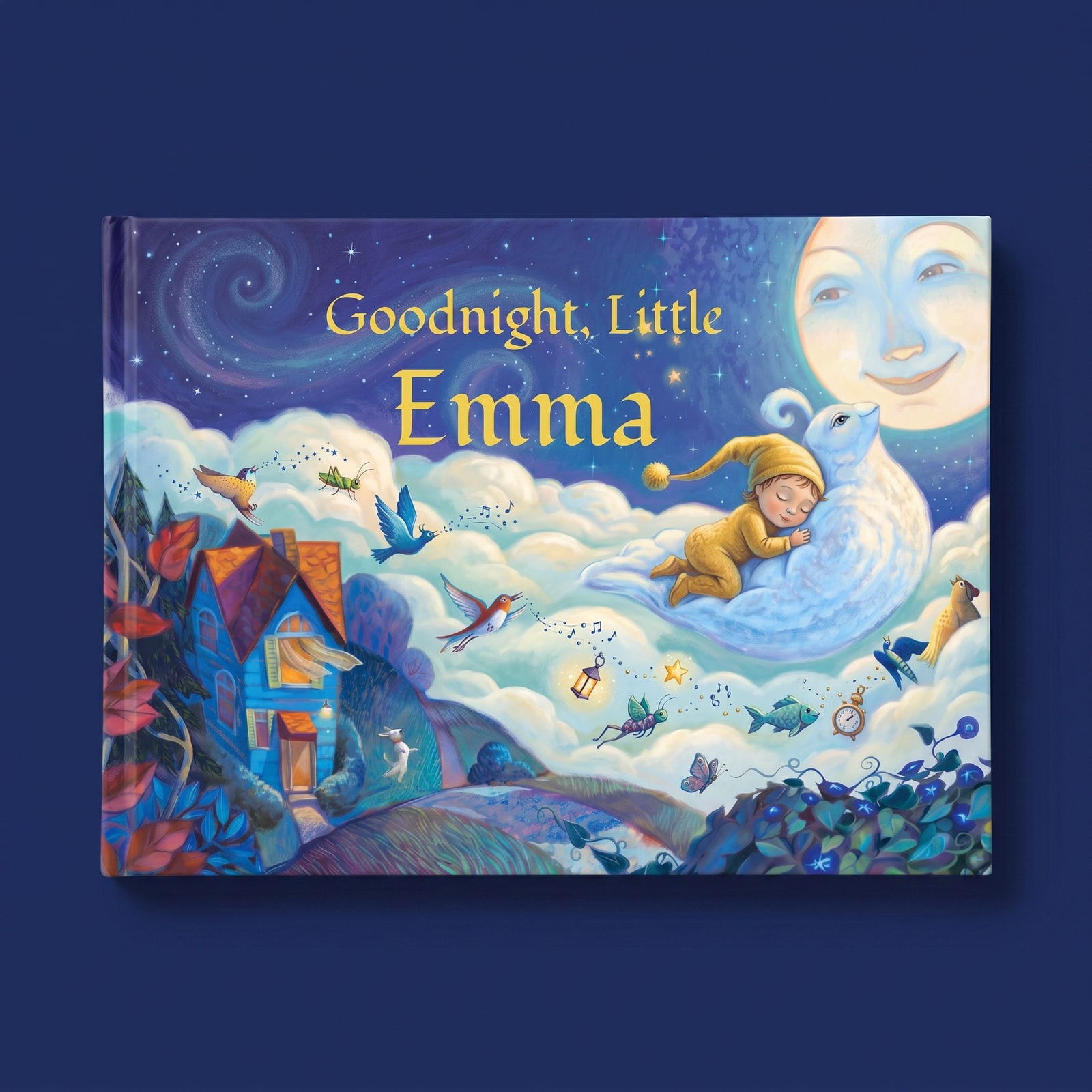 The landscape hardback lying flat on deep indigo, seen from directly above, its night-sky cover with the smiling moon facing up.